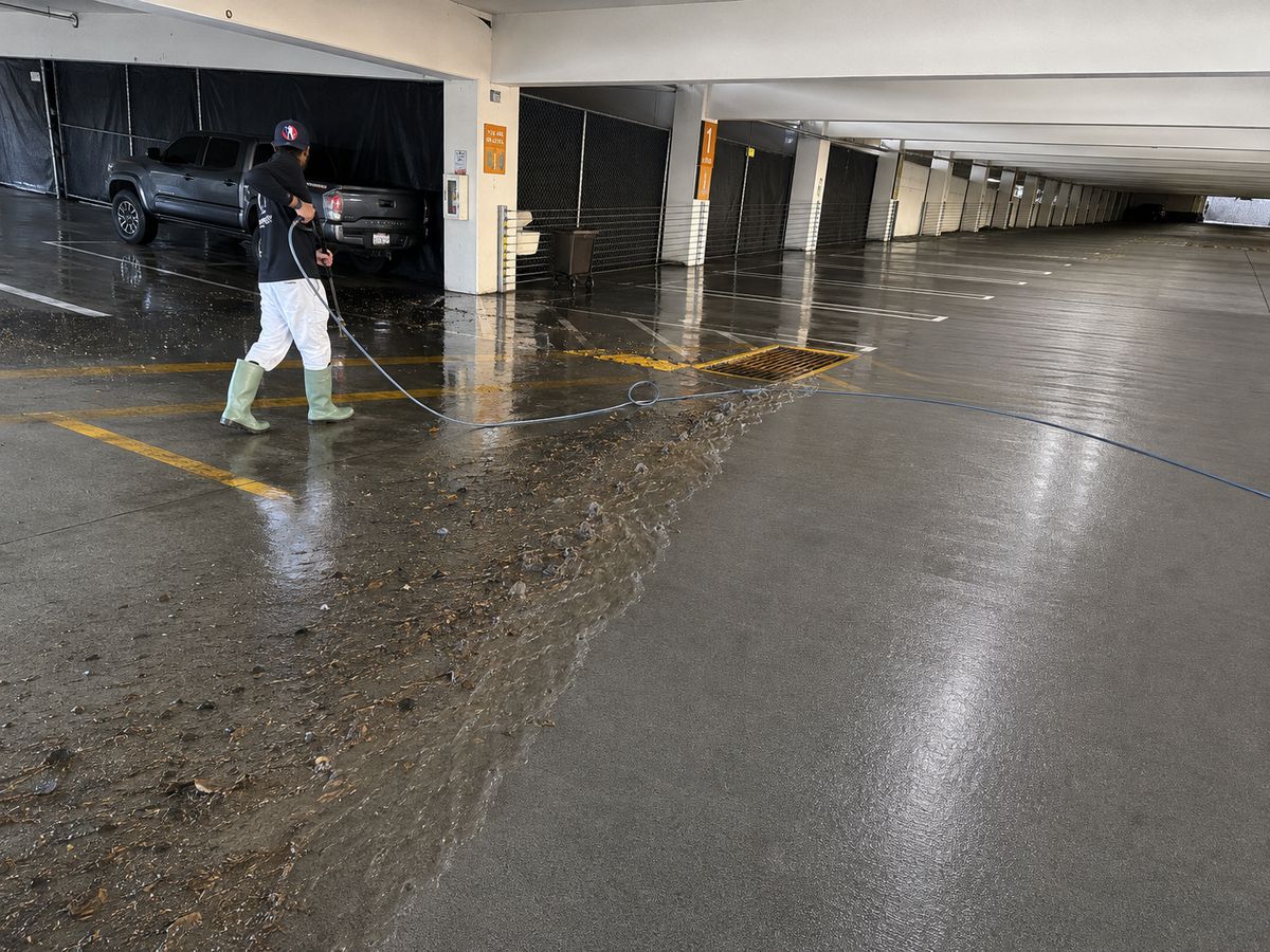 Thomas & Thomas technician pressure washing a commercial parking garage